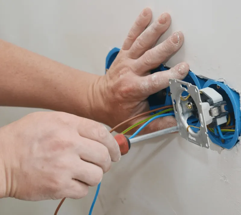 Elektricien plaatst stopcontact in de muur